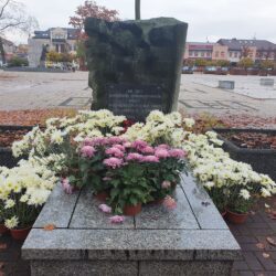 Białe i różowe kwiaty na pomniku