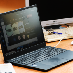 laptop oraz monitor na brązowym biurku