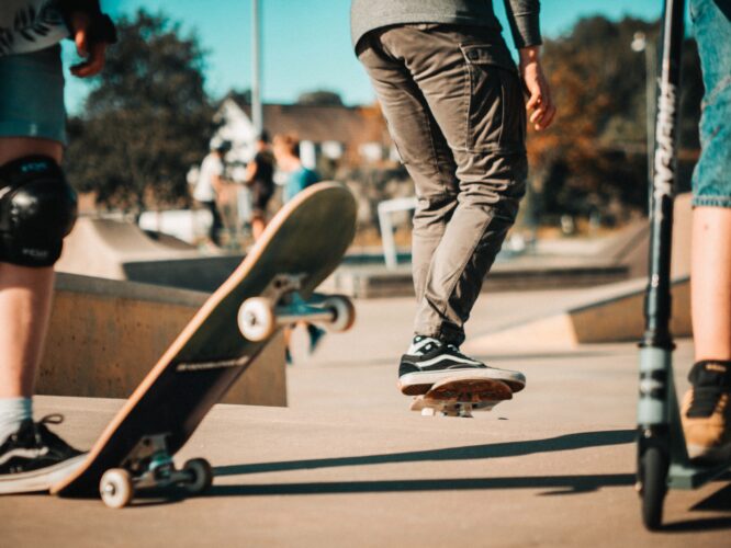 zdjęcie z terenu skateparku - nogi chłopca na deskorolce